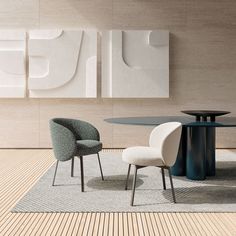 two chairs and a round table in a room with white wall art on the walls