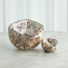 two marble bowls sitting on top of a table