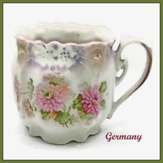 a white cup with flowers painted on it