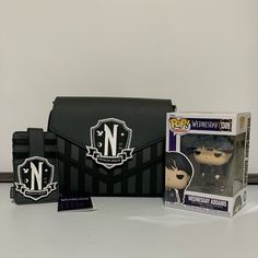 a black and white bag with an n logo on it, next to a pop vinyl figure