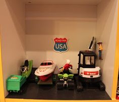 a toy room with toys and other items on the shelf, including a firetruck