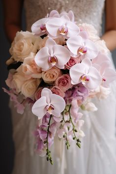 a bride holding a bouquet of pink and white flowers