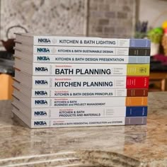 a stack of cookbooks sitting on top of a kitchen counter