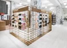 the interior of a women's clothing store with gold and marble display cases on shelves