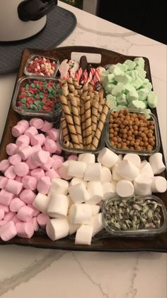 a tray filled with marshmallows and other sweets