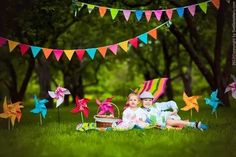 two children sitting in the grass with pinwheels