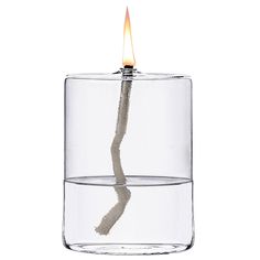 a lit candle in a glass container with water and sand on the bottom that is reflecting light