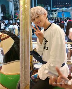 a young man sitting on top of a merry go round