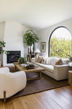 a living room filled with furniture and a fire place in front of a large window