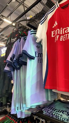 shirts hanging on racks in a store with other items behind them and the words entra la beta