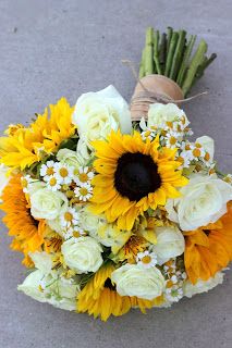 a bouquet of sunflowers and daisies on the ground