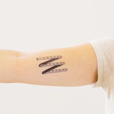 a woman's arm with scissors and measuring tape tattoos on her left arm,