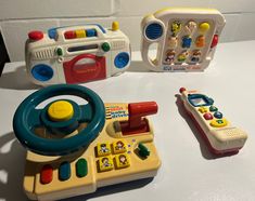 three toys are sitting on a table next to each other, including a toy car and steering wheel