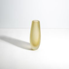 a yellow vase sitting on top of a white table