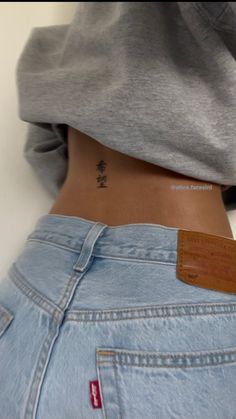 a person with a small tattoo on their lower back and the bottom part of her stomach