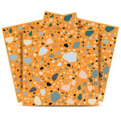 three pieces of orange paper with black and white dots on them, one in the shape of hearts