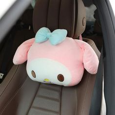 a hello kitty stuffed animal sitting in the back seat of a car with a bow on it's head