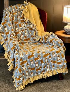 a dog blanket sitting on top of a chair next to a lamp