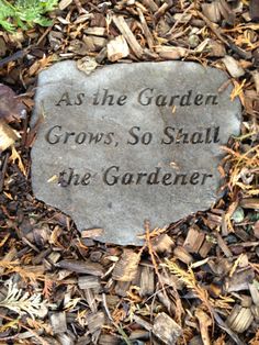 a memorial stone in the middle of some leaves and mulchs that reads as the garden grows, so shall the gardener