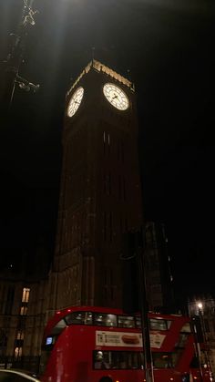 the big ben clock tower towering over the city of london at night with cars passing by