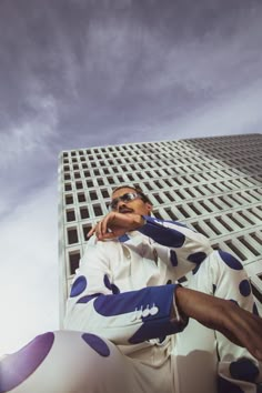 a man sitting in front of a tall building