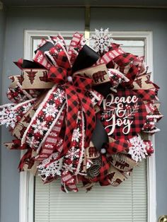 a red and black christmas wreath hanging on the front door