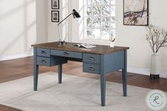 a blue desk with drawers in front of a window and rug on the floor next to it