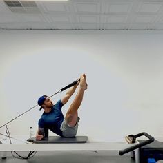 a man is doing exercises on a rowing machine in an office setting with no one around him