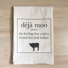 a tea towel with the words deja moo on it and a black cow