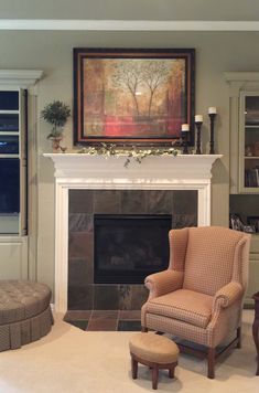 a living room filled with furniture and a fire place in front of a painting on the wall