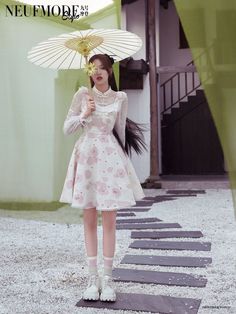 a woman holding an umbrella standing in front of a building