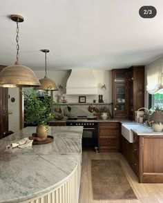 a large kitchen with marble counter tops and wooden cabinetry, along with an island