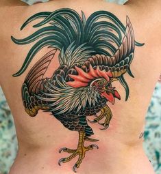 the back of a woman's stomach with a colorful rooster tattoo on her side