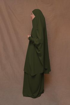 Introducing Army Green Moira Prayer Umrah Gown with Niqab Feature from Annah Hariri. This beautiful gown is made from high-quality Nada abaya fabric and features super light, stretchy jersey sleeves for ultimate comfort. The elasticated waistband and full skirt ensure a flattering and secure fit, while the khimar can be tied at the back of the head for added coverage.But the best part? This gown can also be transformed into a niqaab with just a few simple stitches. So whether you're performing U Green Niqab For Eid, Green Long Sleeve Niqab For Eid, Eid Wedding Solid Color Abaya, Abaya Fabric, Annah Hariri, Modest Activewear, Full Coverage Swimsuit, Back Of The Head, Abaya Dress