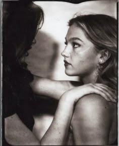 a black and white photo of a woman with her arm around another woman's shoulder