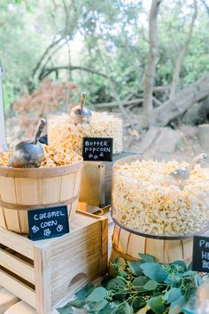 three wooden buckets filled with popcorn sitting next to each other on top of a table