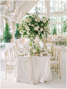 the table is set with white flowers and candles for an elegant wedding reception or special event