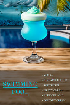 a blue drink sitting on top of a wooden table next to a body of water