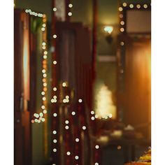 a table topped with a cake covered in frosting next to a window filled with christmas lights