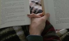 a person is reading a book while laying down