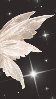 a white feather flying through the air with stars in the background