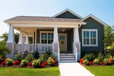 a small gray house with white trim and front porch