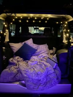 a bed in the back of a truck with purple lights on it's sides