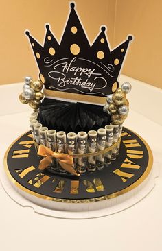 a black and gold birthday cake with a crown on top