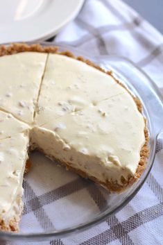 a cheesecake on a glass plate with one slice cut out and ready to be eaten