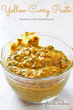 a bowl filled with yellow curry paste on top of a table