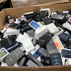 a cardboard box filled with different types of electronic devices on top of each other,