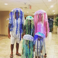 three people wearing jellyfish costumes in an office lobby