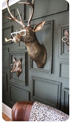 a deer head mounted to the side of a wall with glasses on it's face