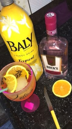 an assortment of alcoholic drinks including gin, oranges and lemonade on a counter